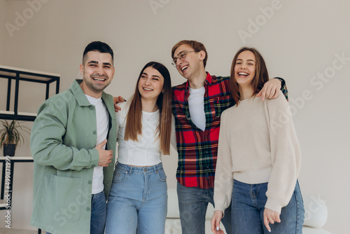 Portrait of happy and smiling friends at home. Friends hug and have a good time together