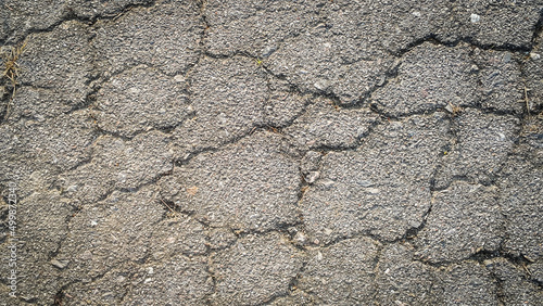 Crack on the asphaltic surface. Natural pattern on textured surface. Ruined of the walkway.