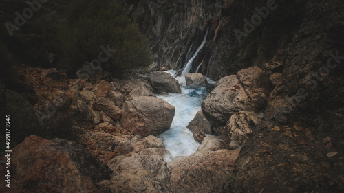 Birth of the Castril river in Granada, Spain. Its transparent and bluish waters run between rocks in the shadows. Special to highlight ecology and nature