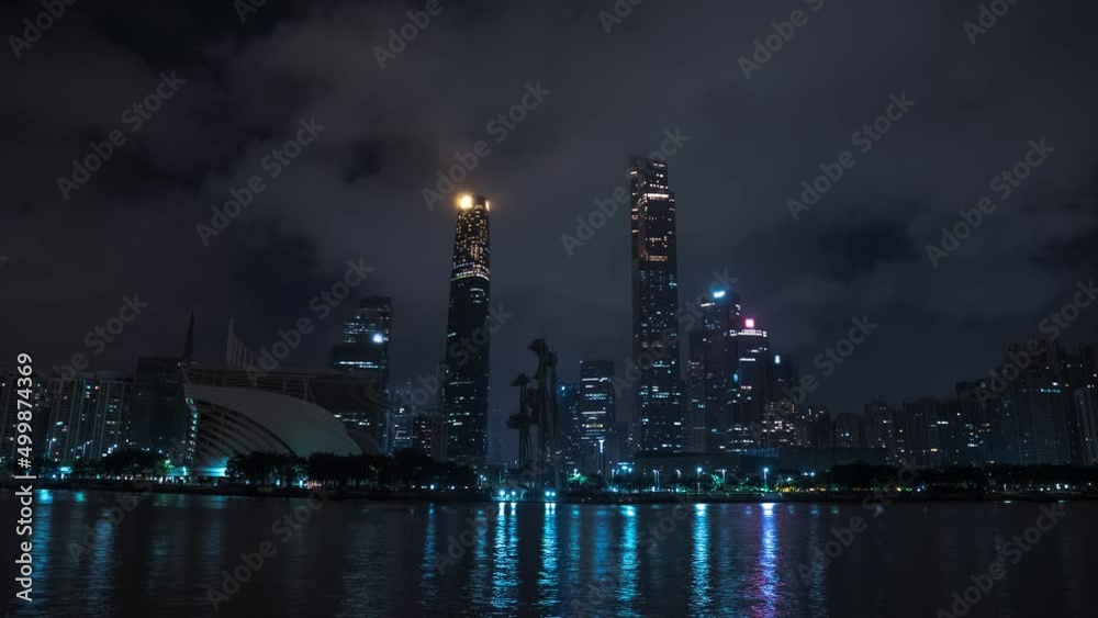 Guangzhou downtown at night, timelapse. Skyscrapers, office buildings, skyline. Clouds are moving fast Guangzhou downtown at night, timelapse. Skyscrapers, office buildings, skyline. Clouds are moving fast