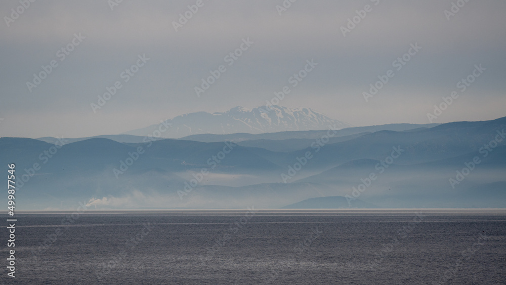 Panorama of beautiful simplistic and minimal natural scenery of Greece combining sea, land, mountains and sky