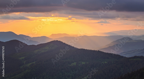 Amazing mountain landscape with colorful vivid sunset on the cloudy sky, natural outdoor travel background.