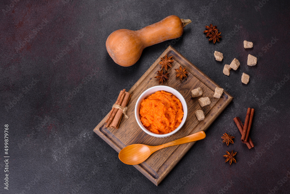 Pumpkin carrot baby puree in bowl on a dark background