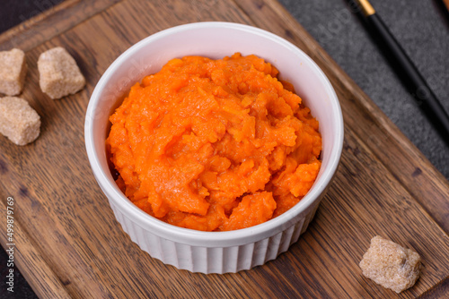 Pumpkin carrot baby puree in bowl on a dark background