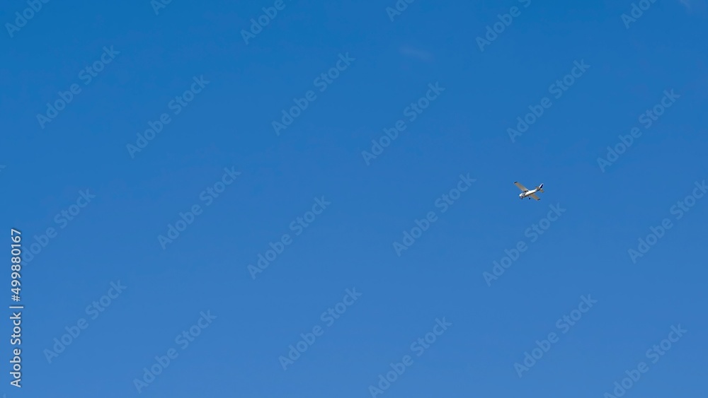 Small recreational plane, ideal for flight practice flying over a blue sky on a clear day Small recreational plane, ideal for flight practice flying over a blue sky on a clear day