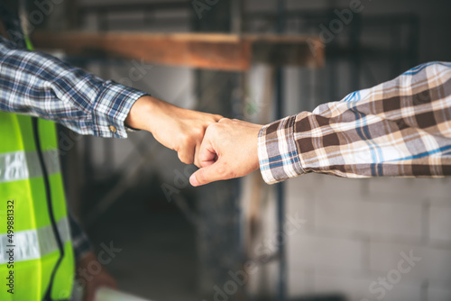 Close up images, hand of two workers are fist bump together with blur background, to worker teamwork and synergy for successful concept. © Anatta_Tan