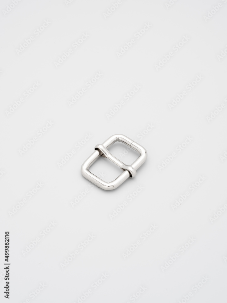 Metal adjusters and frames for making bags and backpacks on a grey background. Chrome-plated metal frames for handbags straps. Sewing accessories, bags making