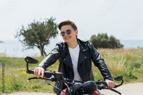 Woman with short hair smiling and being very happy because she is going on an adventure with a motorcycle