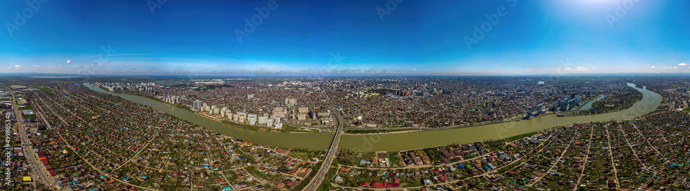 Large aerial panorama of the embankment near the Turgenev bridge in the city of Krasnodar on a sunny April day