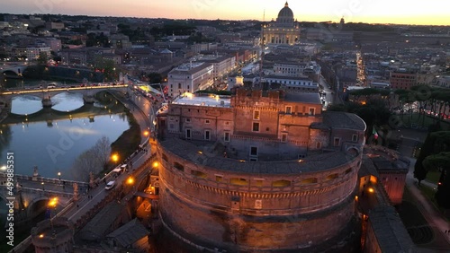 flying above Castel Sant'Angelo and San Pietro in Rome at night. Panoramic aerial view of the Tiber river, its bridges and St. Peter's, Vatican City. Center city of Roma, Italy in the evening photo