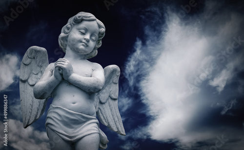 Foto Little guardian angel against blue sky. Copy space for design.