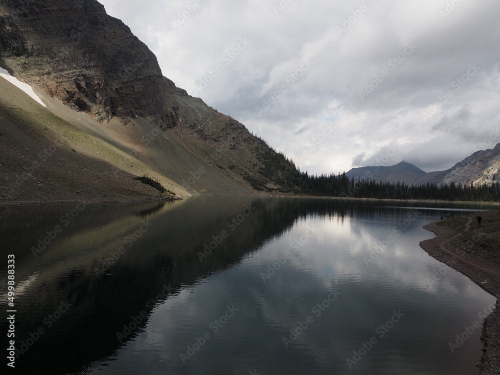 Reflection of clouds in the mountains at Crypt Lake at Waterton Lake National Park