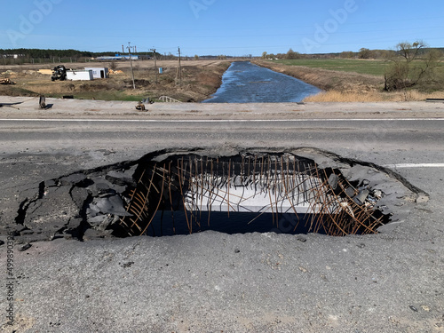 Irpin, Ukraine - April 01, 2022: War in Ukraine. Chaos and devastation on the outskirts of Irpin. Blown up bridge as a result of rocket fire and shelling of a peaceful city photo