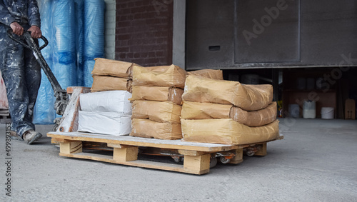 Production. Industrial workshops. The worker transports sacks filled with bulk industrial mixtures.