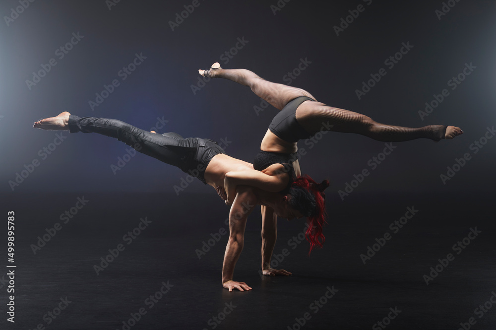 Circus acrobats man and woman showing tricks isolated on black background