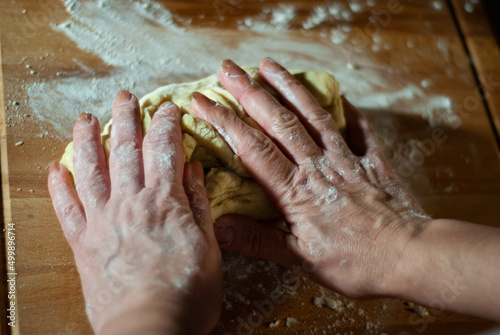 Baker s hands working the flour dough on a wooden board