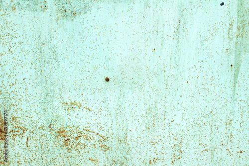 The texture of a green metal sheet with rust inclusions