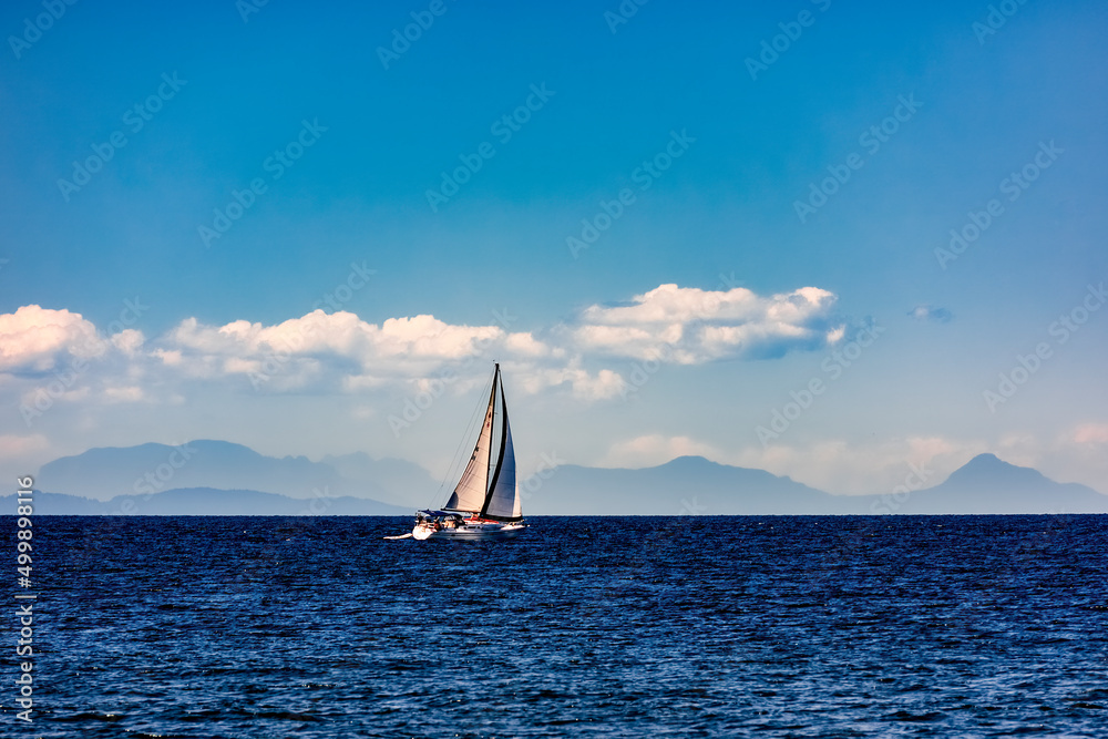 Fototapeta premium sail boat with mountains and clouds