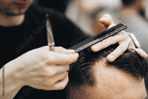 Hairdresser for men barber shop. Process of cutting hair.
