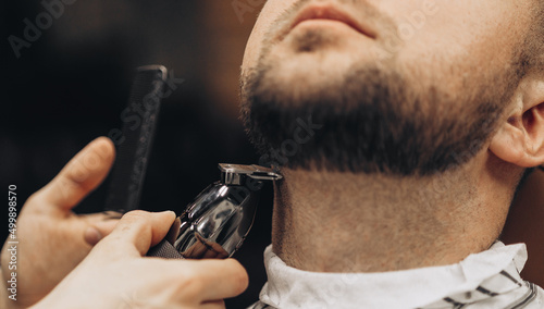 Barber beard styling and cut process. Barbershop for men.