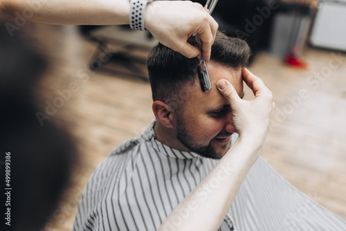 Vintage toning, master barber makes hair to man hipster © ALEXSTUDIO