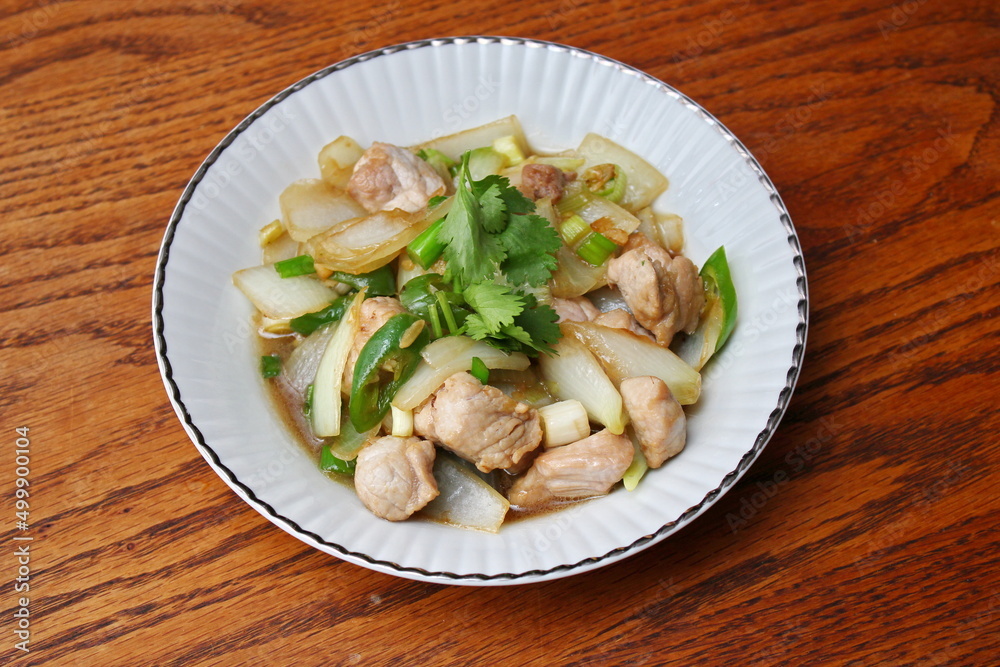 Stir-fried pork with chilli with onions and spring onions served in a white plate, Stir-fried pork with chilli is a popular Thai dish that Thai people eat. Stir-fried pork with chilli with onions and spring onions served in a white plate, Stir-fried pork with chilli is a popular Thai dish that Thai people eat.