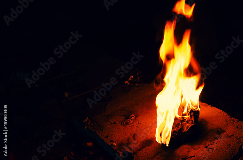 Bright fire torch on a dark background. White yellow red flame.