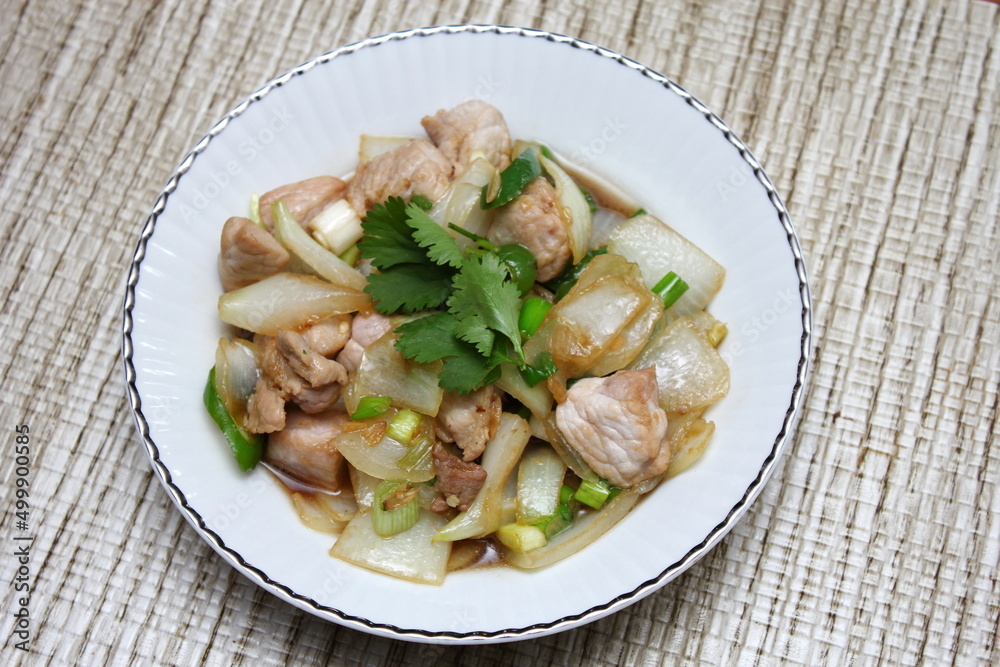 Stir-fried pork with chilli with onions and spring onions served in a white plate, Stir-fried pork with chilli is a popular Thai dish that Thai people eat. Stir-fried pork with chilli with onions and spring onions served in a white plate, Stir-fried pork with chilli is a popular Thai dish that Thai people eat.