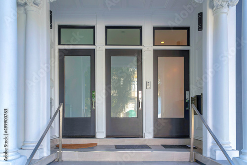 Three black front doors with glass panels and transom windows at San Francisco, California