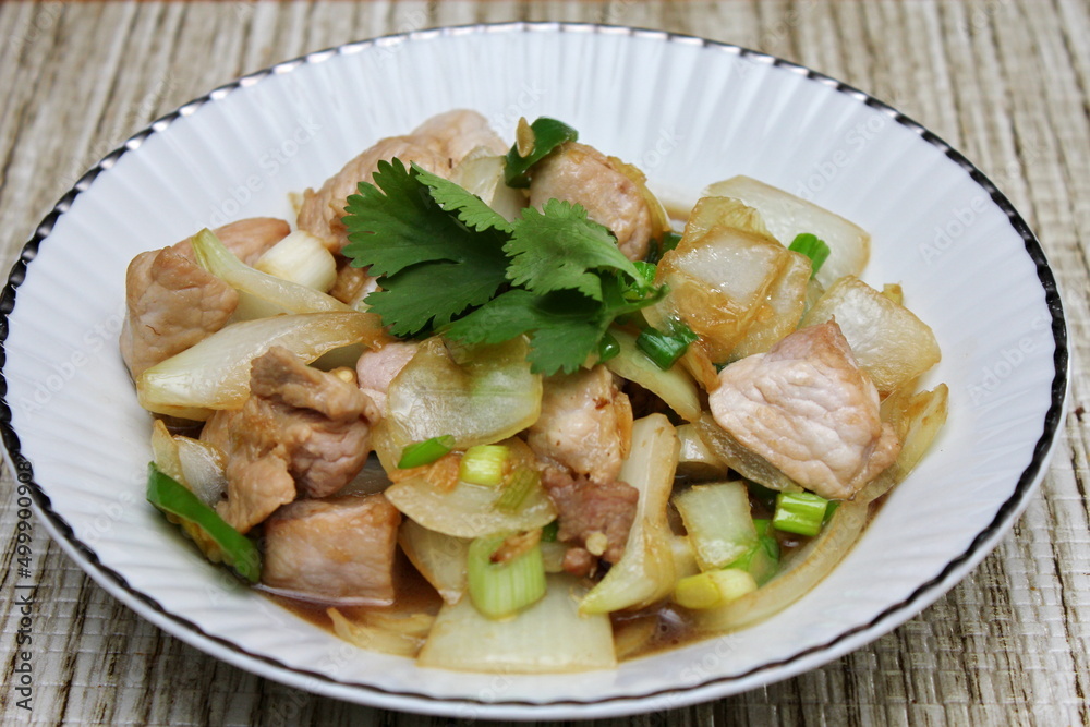 Stir-fried pork with chilli with onions and spring onions served in a white plate, Stir-fried pork with chilli is a popular Thai dish that Thai people eat. Stir-fried pork with chilli with onions and spring onions served in a white plate, Stir-fried pork with chilli is a popular Thai dish that Thai people eat.