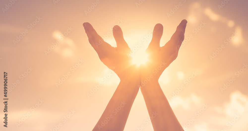Hands reaching out to sky, warm sunshine in the palm of hands.	 Spiritual prayer, recovery, healing concept. 