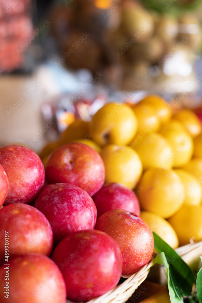 Red and yellow plums close-up on the market. Selective focus. Red and yellow plums close-up on the market. Selective focus.