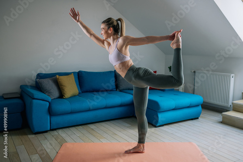 Woman in Lord of the dance yoga pose training at home