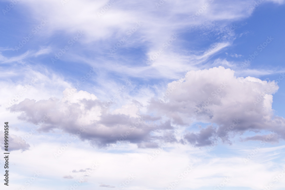 Beautiful epic soft gentle cloudy blue sky with many white cirrus and fluffy clouds, abstract background texture, heaven