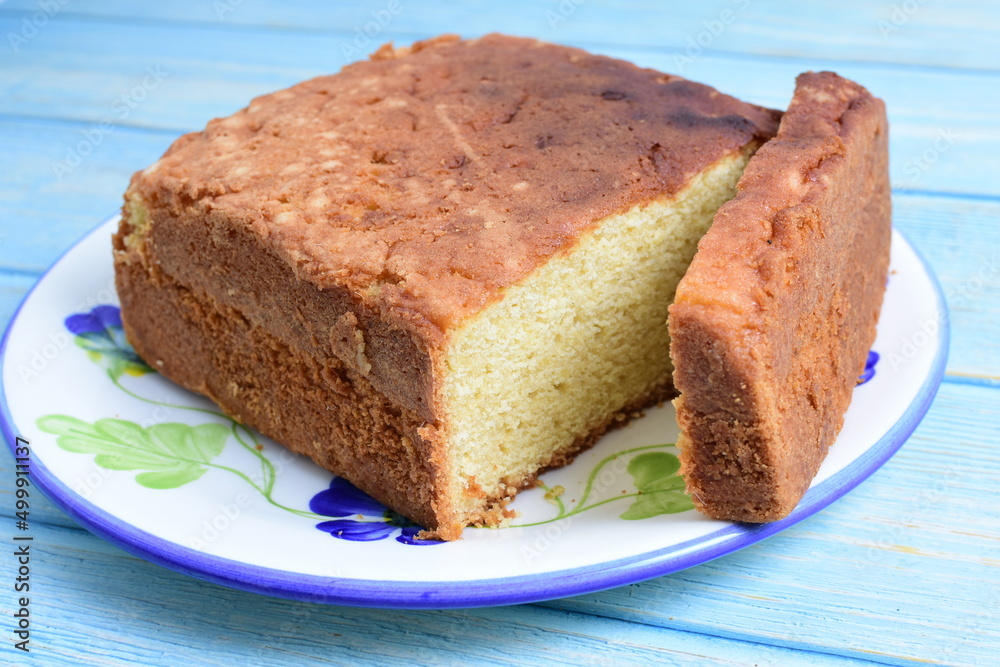 Homemade vanilla cake, displayed on plate and wooden background Homemade vanilla cake, displayed on plate and wooden background