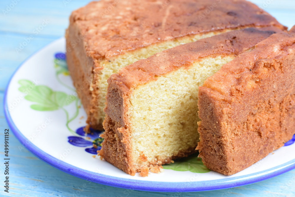 Homemade vanilla cake, displayed on plate and wooden background Homemade vanilla cake, displayed on plate and wooden background