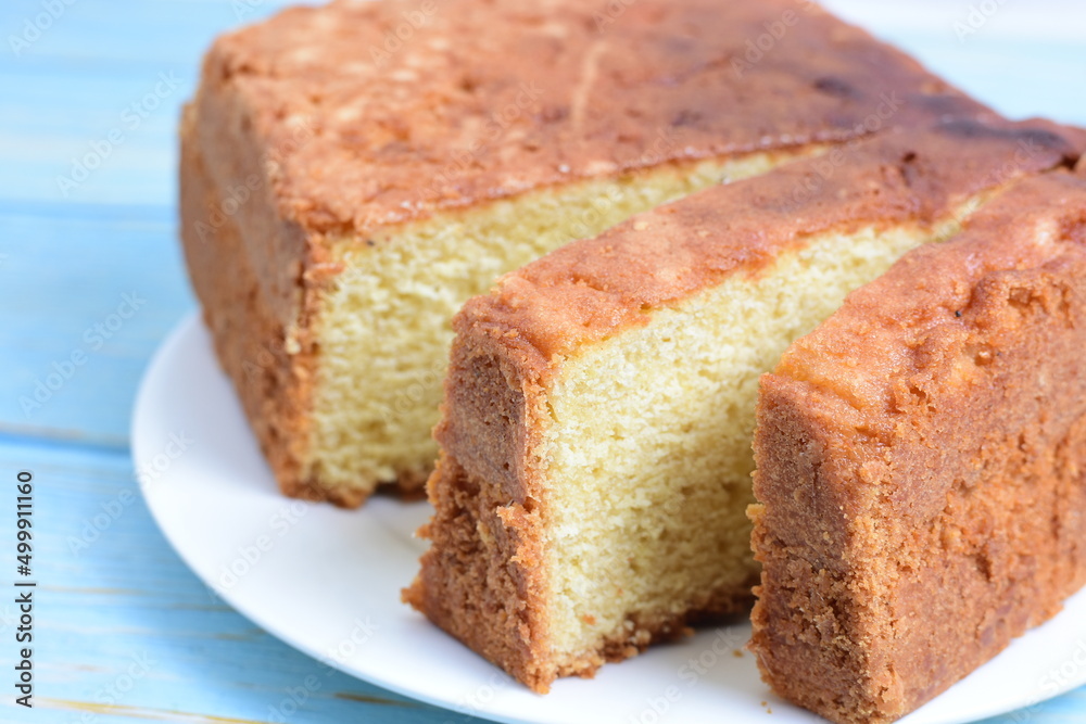 Homemade vanilla cake, displayed on plate and wooden background