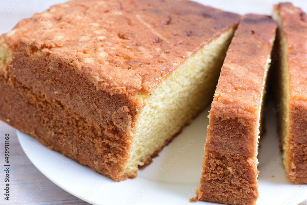 Homemade vanilla cake, displayed on plate and wooden background Homemade vanilla cake, displayed on plate and wooden background