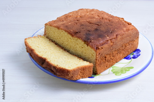 Homemade vanilla cake, displayed on plate and wooden background