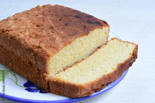Homemade vanilla cake, displayed on plate and wooden background
