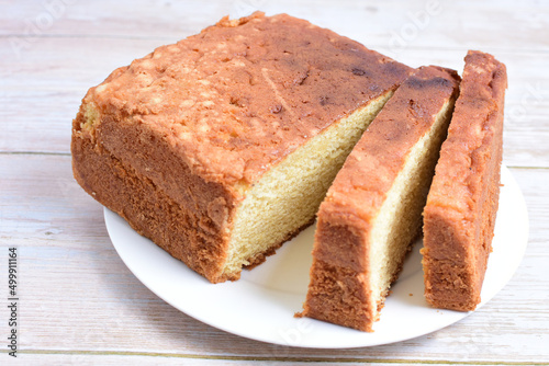 Homemade vanilla cake, displayed on plate and wooden background