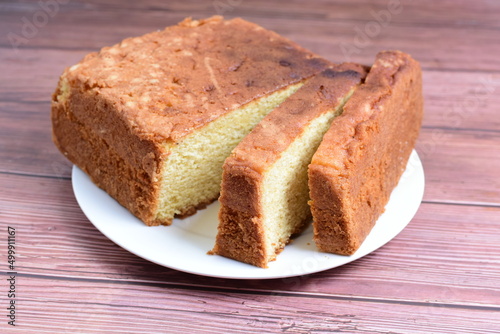 Homemade vanilla cake, displayed on plate and wooden background