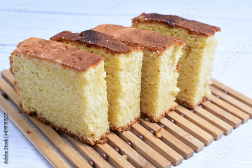 Homemade vanilla cake  displayed on a plate and portioned and on a wooden background