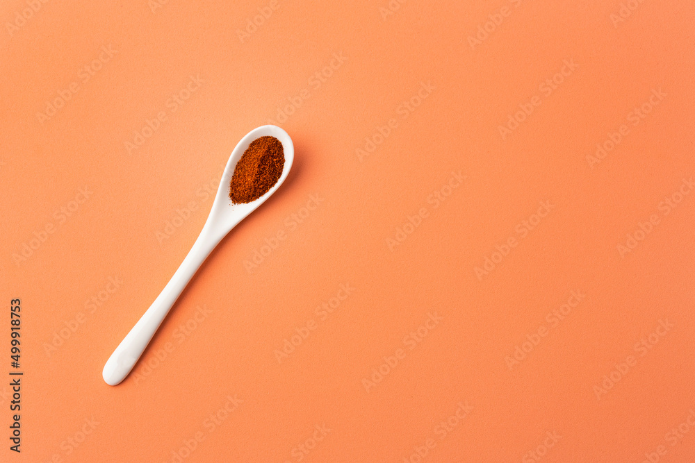 Capsicum annuum - Red chili powder or paprika in the ceramic spoon Capsicum annuum - Red chili powder or paprika in the ceramic spoon