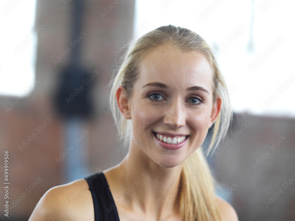 She is happier since adopting a healthier lifestyle. Portrait of an attractive young woman in the gym.