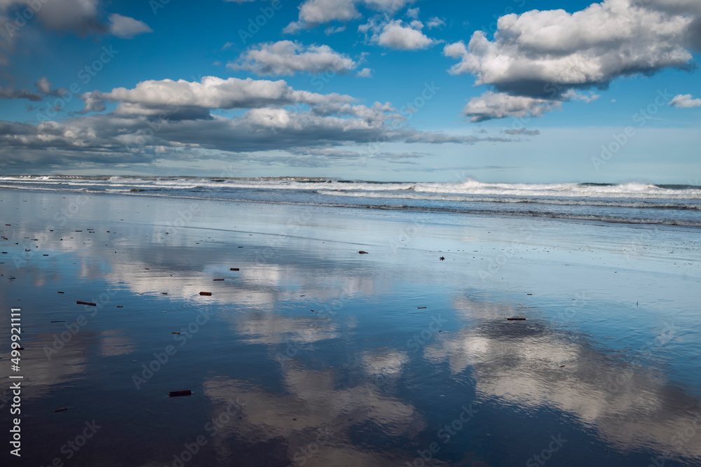 Seascape. Reflection of clouds on the shore in the water. Sunny day.