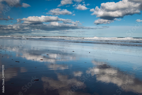 Seascape. Reflection of clouds on the shore in the water. Sunny day.