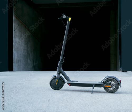 Foto Modern clean e scooter in front garages in the city, dark grungy background