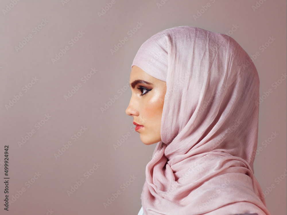 She keeps her eyes on the prize. Studio shot of a confident young woman wearing a colorful head scarf while posing against a grey background.