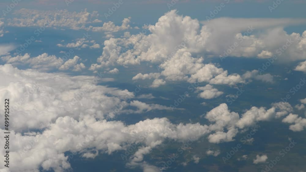 Flight over white clouds at blue sky background. View from airplane window. Adventure, travel or journey concept Flight over white clouds at blue sky background. View from airplane window. Adventure, travel or journey concept